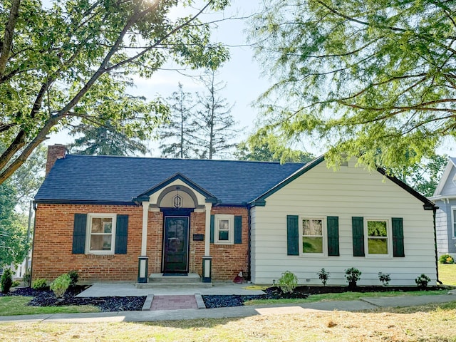 69 N Cherry St, Mount Gilead, OH 43338 - view of front of home featuring a chimney, brick siding, and a shingled roof