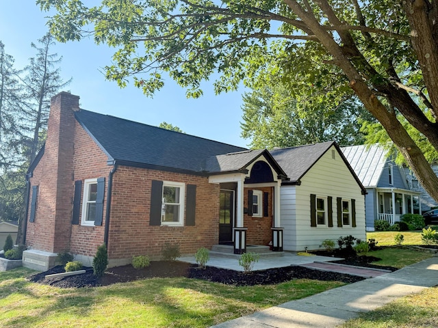 69 N Cherry St, Mount Gilead, OH 43338 - view of front of property with a chimney, brick siding, a front yard, and a shingled roof