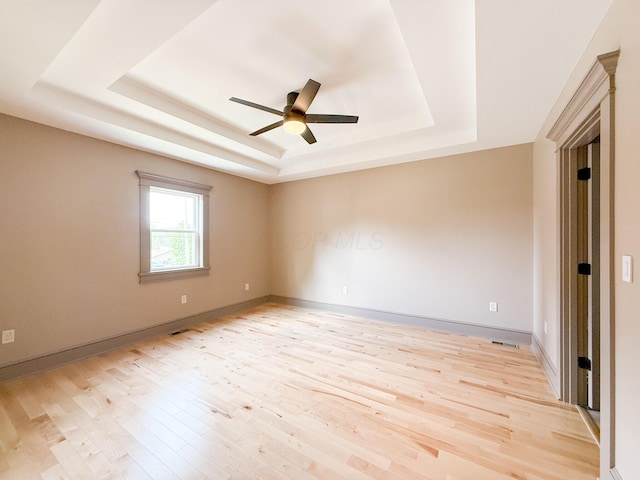 69 N Cherry St, Mount Gilead, OH 43338 - spare room with a raised ceiling, light wood-style floors, and a ceiling fan