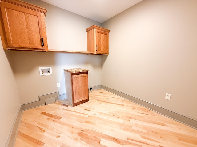 69 N Cherry St, Mount Gilead, OH 43338 - laundry area featuring light wood-style floors, cabinet space, and hookup for a washing machine