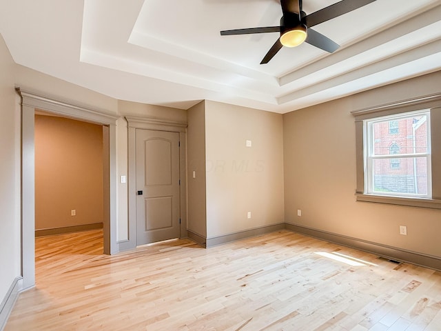 69 N Cherry St, Mount Gilead, OH 43338 - empty room with a tray ceiling, light wood-type flooring, and a ceiling fan