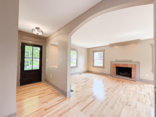 69 N Cherry St, Mount Gilead, OH 43338 - entryway with arched walkways, light wood finished floors, and a fireplace