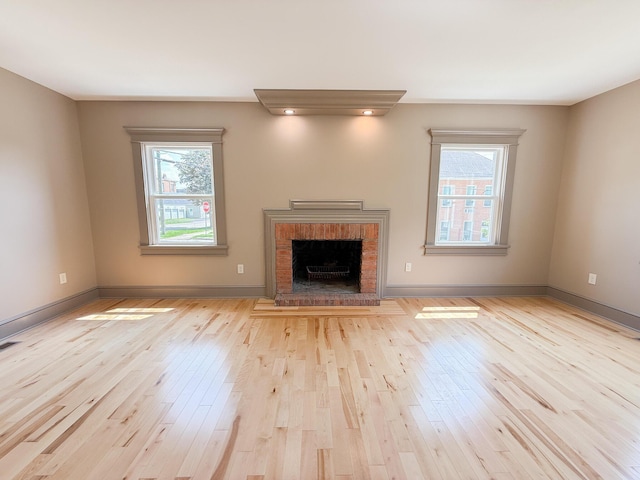 69 N Cherry St, Mount Gilead, OH 43338 - unfurnished living room featuring healthy amount of natural light, light wood finished floors, and a brick fireplace