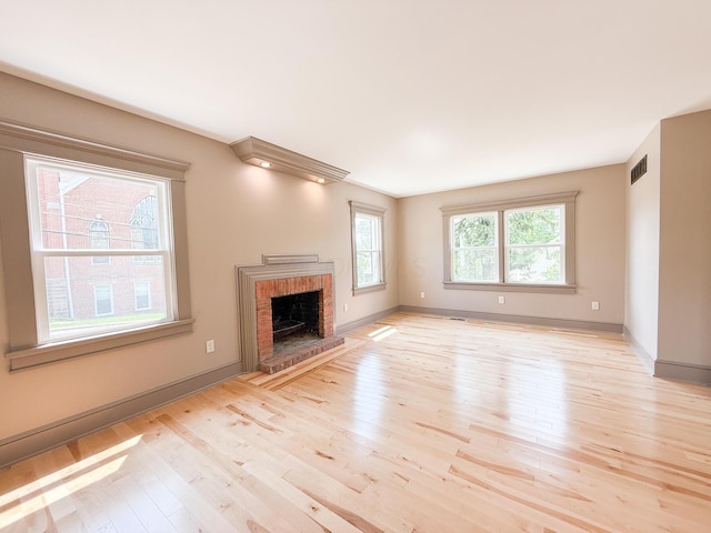 69 N Cherry St, Mount Gilead, OH 43338 - unfurnished living room with light wood-style floors and a brick fireplace