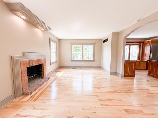 69 N Cherry St, Mount Gilead, OH 43338 - unfurnished living room featuring arched walkways, light wood-style flooring, a fireplace, and recessed lighting