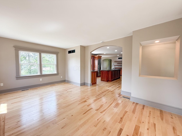 69 N Cherry St, Mount Gilead, OH 43338 - unfurnished living room featuring arched walkways, light wood-style flooring, and recessed lighting