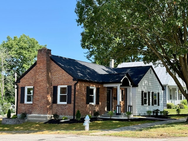 69 N Cherry St, Mount Gilead, OH 43338 - view of front of home featuring a chimney, brick siding, a front yard, and a shingled roof