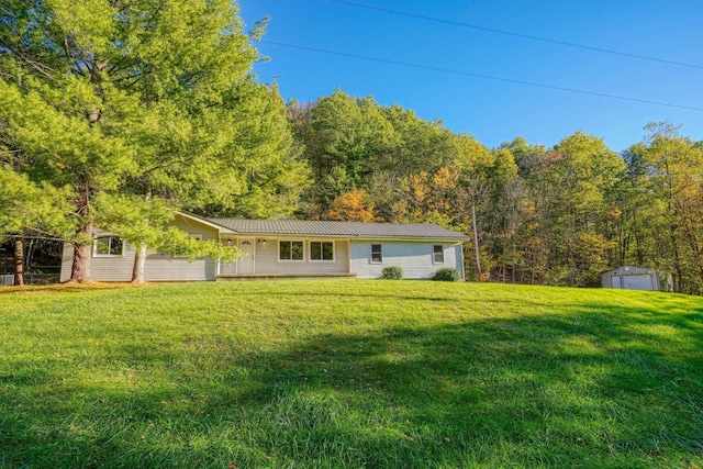 368 Mingo Rd, Chillicothe, OH 45601 - view of front facade featuring a front lawn, a metal roof, an outdoor structure, and a view of trees