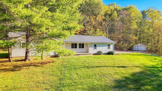 368 Mingo Rd, Chillicothe, OH 45601 - view of front of property with an outdoor structure, a front yard, a garage, a metal roof, and a forest view
