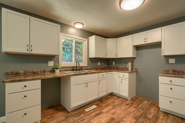 368 Mingo Rd, Chillicothe, OH 45601 - kitchen with wood finished floors, dark countertops, white cabinets, and a textured ceiling