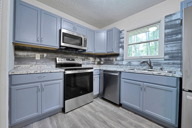1142 Rozelle Creek Rd, Chillicothe, OH 45601 - kitchen featuring appliances with stainless steel finishes, a textured ceiling, light wood finished floors, light stone counters, and gray cabinets