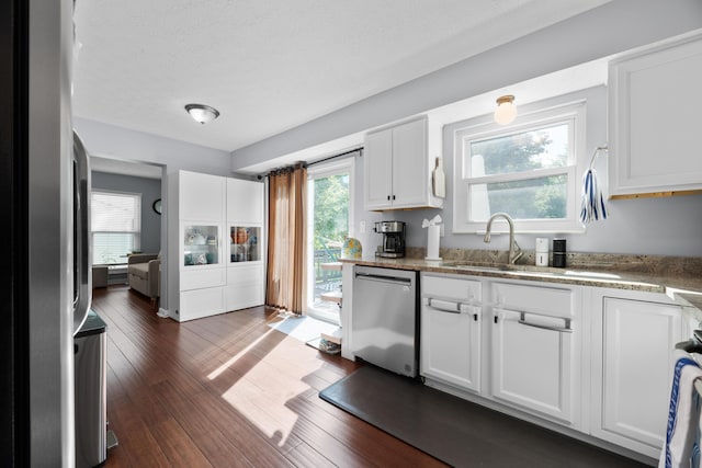 3823 Ramblehurst Rd, Columbus, OH 43221 - kitchen featuring stainless steel dishwasher, white cabinetry, dark wood-style flooring, and light stone counters