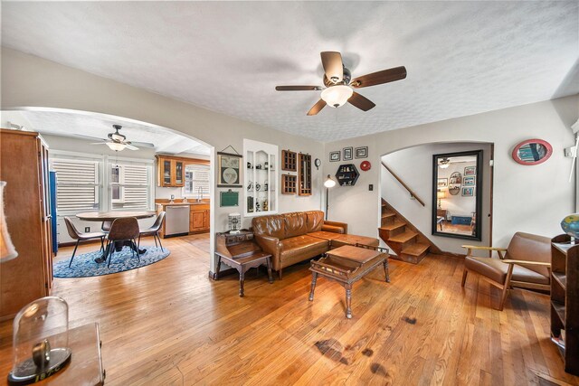 1467 Melrose Ave, Columbus, OH 43224 - living room with arched walkways, a ceiling fan, light wood-type flooring, and a textured ceiling