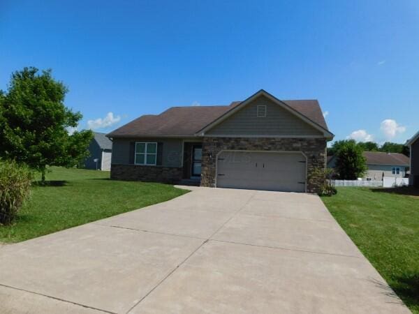 32340 Lilac Ln, Logan, OH 43138 - view of front of house with an attached garage, a front yard, concrete driveway, and stone siding