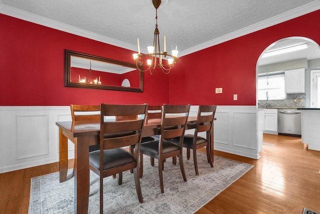 5683 Levi Kramer Blvd, Canal Winchester, OH 43110 - dining area featuring wainscoting, a decorative wall, light wood finished floors, a chandelier, and a textured ceiling