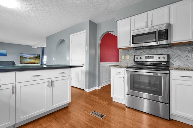 5683 Levi Kramer Blvd, Canal Winchester, OH 43110 - kitchen with stainless steel appliances, white cabinetry, dark countertops, backsplash, and a textured ceiling