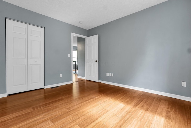 5683 Levi Kramer Blvd, Canal Winchester, OH 43110 - unfurnished bedroom with light wood-type flooring, a closet, and a textured ceiling