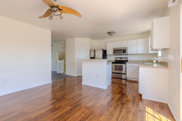7145 Billy Goat Dr, New Albany, OH 43054 - kitchen featuring appliances with stainless steel finishes, a center island, white cabinetry, a ceiling fan, and dark wood-type flooring