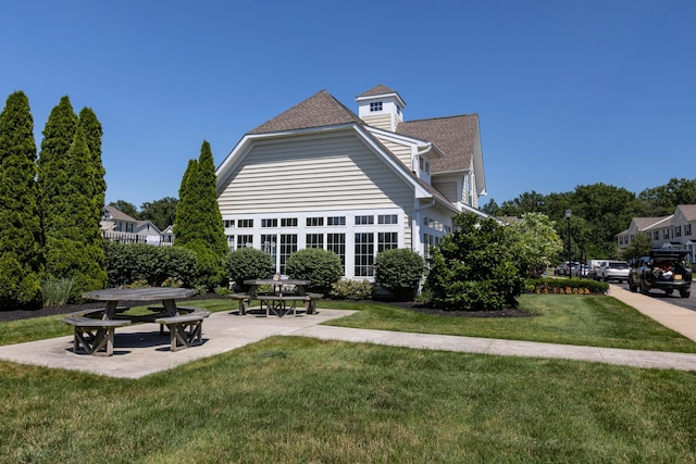 7145 Billy Goat Dr, New Albany, OH 43054 - back of property with a lawn, a patio area, and a shingled roof