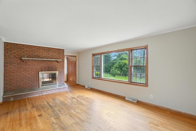 899 Meadowview Dr, Columbus, OH 43224 - unfurnished living room with wood finished floors, a brick fireplace, and ornamental molding