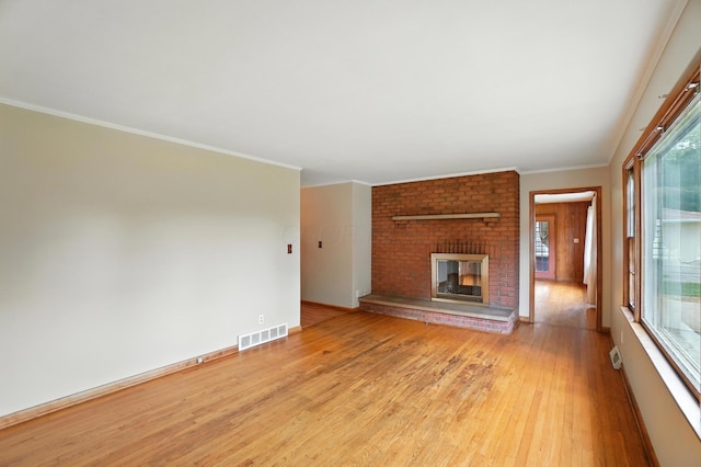 899 Meadowview Dr, Columbus, OH 43224 - unfurnished living room featuring light wood-style floors, a brick fireplace, and crown molding