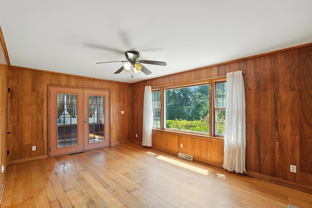 899 Meadowview Dr, Columbus, OH 43224 - unfurnished room featuring french doors, a ceiling fan, wooden walls, and light wood-style flooring