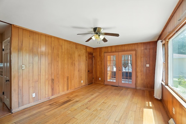 899 Meadowview Dr, Columbus, OH 43224 - empty room featuring ceiling fan, light wood-style floors, wood walls, french doors, and a baseboard heating unit