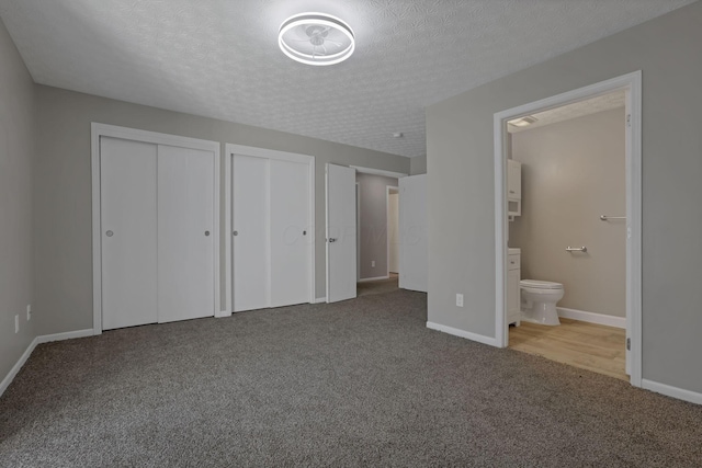 6658 Lagrange Dr Unit 43E, Canal Winchester, OH 43110 - unfurnished bedroom featuring multiple closets, carpet floors, a textured ceiling, and connected bathroom