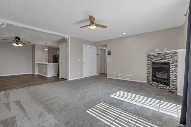 6658 Lagrange Dr Unit 43E, Canal Winchester, OH 43110 - unfurnished living room featuring a ceiling fan, carpet, a tile fireplace, and a textured ceiling