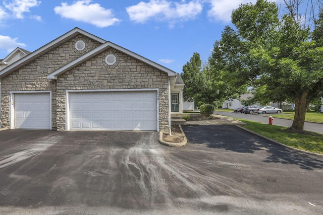 6658 Lagrange Dr Unit 43E, Canal Winchester, OH 43110 - view of front of home featuring driveway, stone siding, and an attached garage