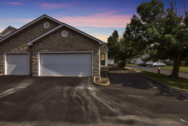 6658 Lagrange Dr Unit 43E, Canal Winchester, OH 43110 - view of front of home featuring asphalt driveway, stone siding, and an attached garage