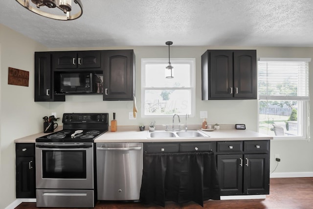 664 Dukewell Pl, Galloway, OH 43119 - kitchen with appliances with stainless steel finishes, a textured ceiling, light countertops, dark wood-type flooring, and hanging light fixtures