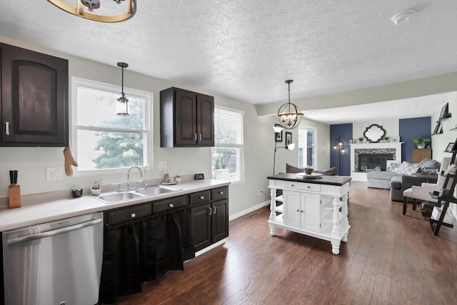 664 Dukewell Pl, Galloway, OH 43119 - kitchen with stainless steel dishwasher, dark wood-type flooring, a textured ceiling, a chandelier, and a fireplace