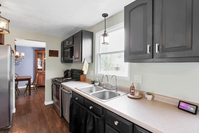 664 Dukewell Pl, Galloway, OH 43119 - kitchen with stainless steel appliances, dark wood-type flooring, light countertops, a chandelier, and pendant lighting