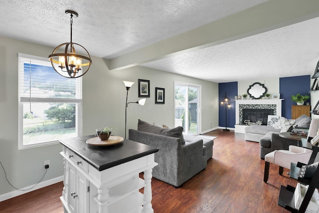 664 Dukewell Pl, Galloway, OH 43119 - living area with a chandelier, a textured ceiling, dark wood finished floors, a tiled fireplace, and beam ceiling