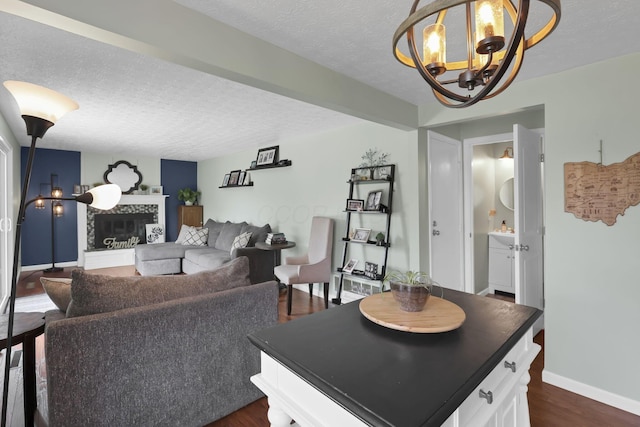 664 Dukewell Pl, Galloway, OH 43119 - living room featuring a chandelier, dark wood-type flooring, a textured ceiling, and a tile fireplace