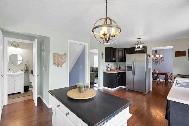 664 Dukewell Pl, Galloway, OH 43119 - kitchen featuring stainless steel fridge, a chandelier, dark wood finished floors, decorative light fixtures, and white cabinetry