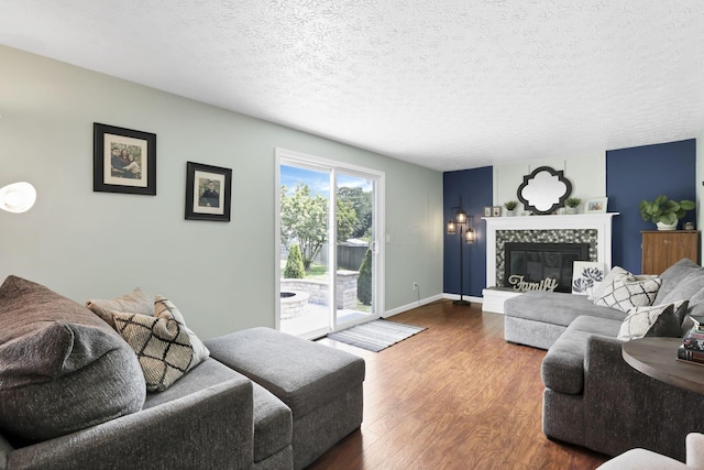 664 Dukewell Pl, Galloway, OH 43119 - living area with wood finished floors, a tiled fireplace, and a textured ceiling