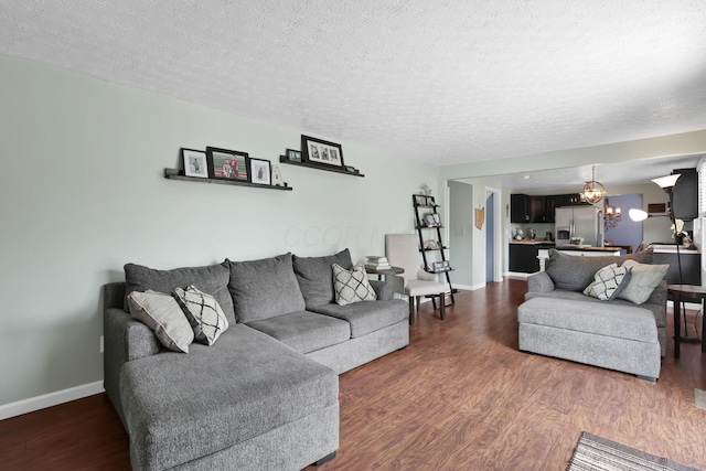 664 Dukewell Pl, Galloway, OH 43119 - living area featuring dark wood-style flooring, a textured ceiling, and a chandelier