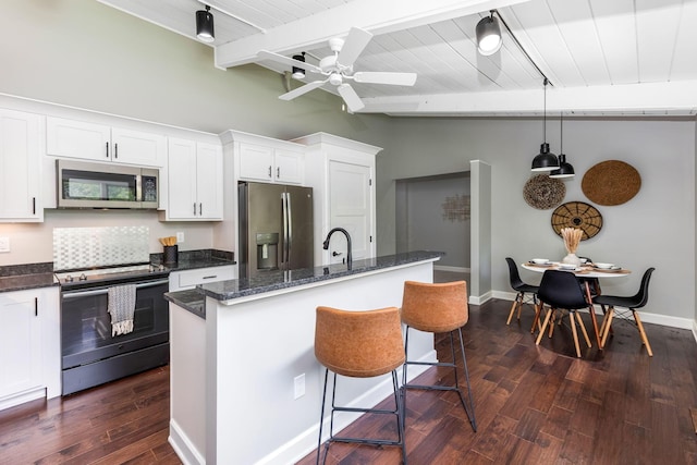 2109 W 5th Ave Unit C, Grandview Heights, OH 43212 - kitchen with appliances with stainless steel finishes, a kitchen island with sink, white cabinets, dark wood finished floors, and dark stone countertops
