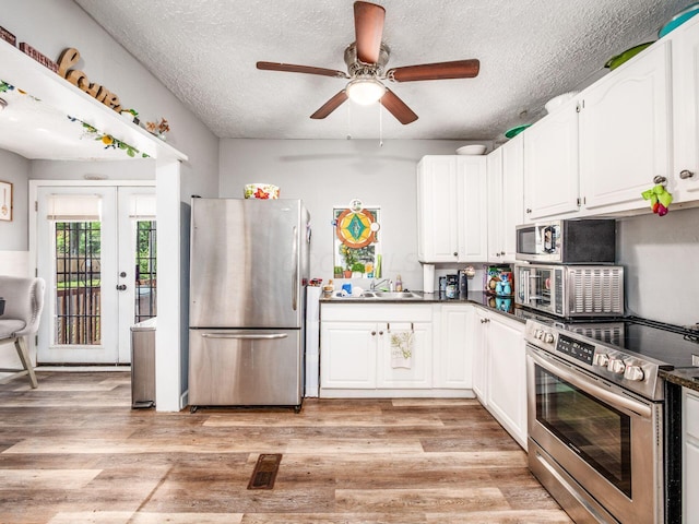 2640-2642 W Broad St, Columbus, OH 43204 - kitchen with appliances with stainless steel finishes, a textured ceiling, a ceiling fan, white cabinetry, and dark countertops