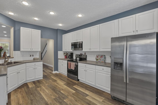 6041 Tetlin Field Dr, New Albany, OH 43054 - kitchen featuring stainless steel appliances, dark wood-style floors, a textured ceiling, tasteful backsplash, and white cabinetry