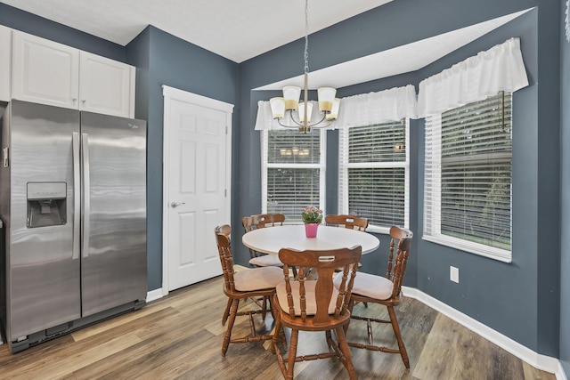 6041 Tetlin Field Dr, New Albany, OH 43054 - dining area with a chandelier and light wood-type flooring