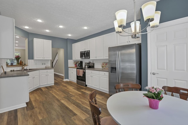 6041 Tetlin Field Dr, New Albany, OH 43054 - kitchen with stainless steel appliances, a chandelier, tasteful backsplash, white cabinetry, and a textured ceiling