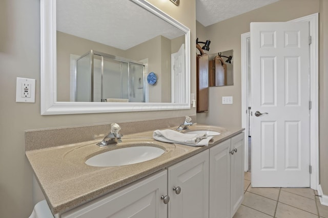 6041 Tetlin Field Dr, New Albany, OH 43054 - full bath featuring double vanity, a shower stall, tile patterned flooring, and a textured ceiling