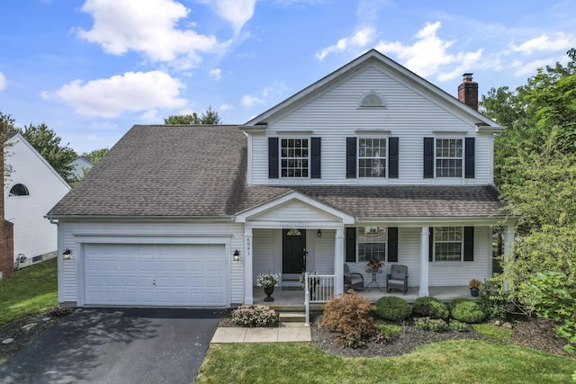 6041 Tetlin Field Dr, New Albany, OH 43054 - traditional-style home with covered porch, asphalt driveway, a garage, a chimney, and roof with shingles