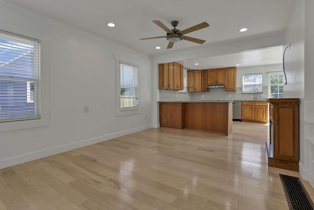 1808 Brentnell Ave, Columbus, OH 43219 - kitchen with light wood-type flooring, a peninsula, a ceiling fan, stainless steel dishwasher, and brown cabinetry
