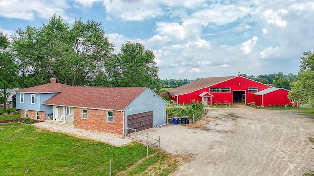 3910 Summit View Rd, Dublin, OH 43016 - view of side of property with dirt driveway, brick siding, a garage, a chimney, and a yard