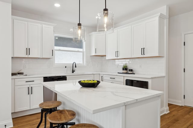 86 W N Broadway, Columbus, OH 43214 - kitchen featuring light wood finished floors, white cabinetry, a breakfast bar, dishwashing machine, and recessed lighting