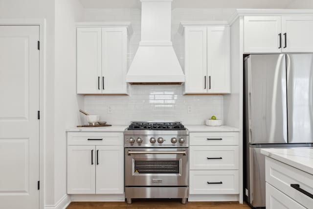86 W N Broadway, Columbus, OH 43214 - kitchen featuring stainless steel appliances, custom range hood, decorative backsplash, white cabinets, and light stone counters